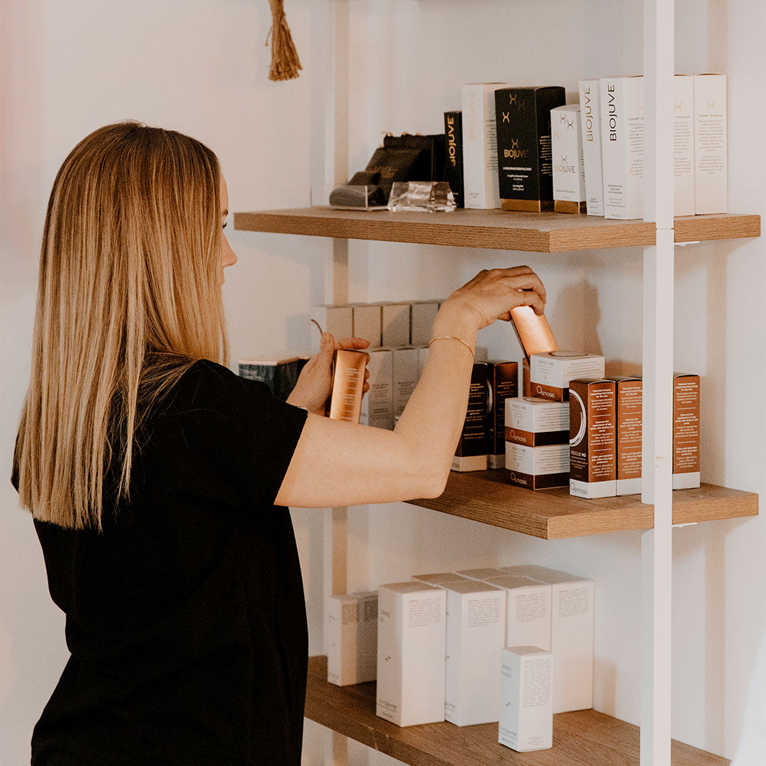Amanda Brown placing skin care on shelf at Neves Skin Studio